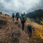 3 people hiking on mountain during daytime