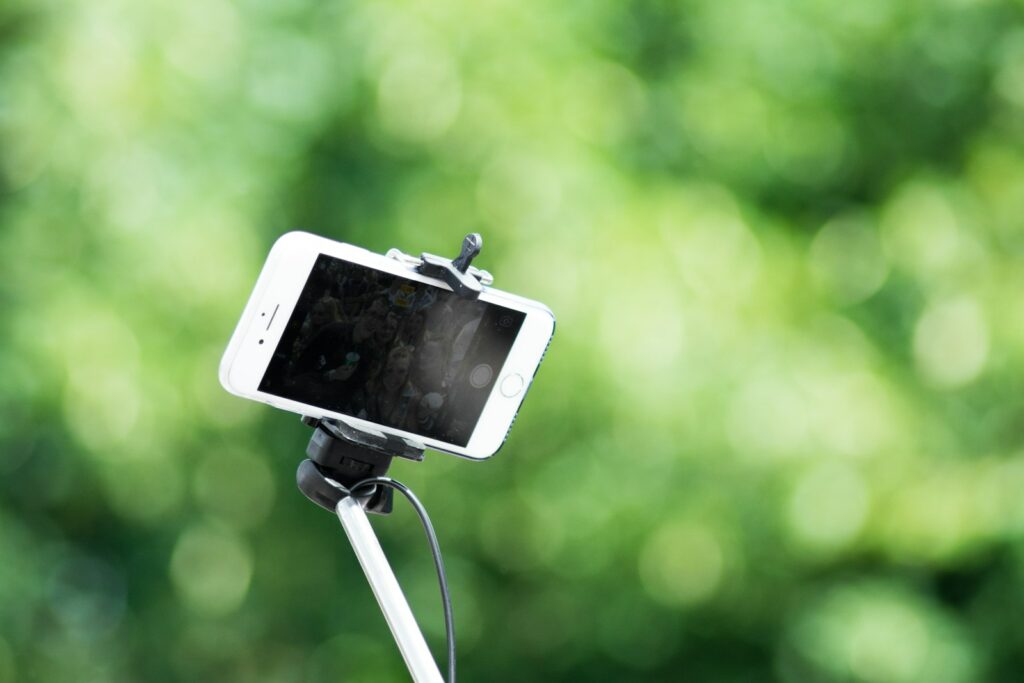 shallow focus photography of iPhone smartphone with Selfie Stick