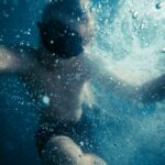 boy in black shorts under water